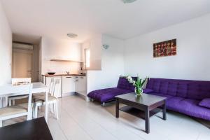 a living room with a purple couch and a table at App Zlatar in Umag