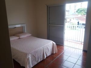 a bedroom with a bed and a large window at Sobrado Guaratuba in Guaratuba