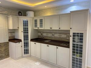 a large white kitchen with white cabinets and tile floors at شقق بيات العالية وادي بن هشبل Bayat Al aliah Apartments in Wadi bin Hashbal in Bin Hashbal +17 photos
