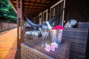a table with a bucket and a wine glass and flowers at Pousada Seu Dodó in Fernando de Noronha