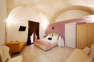 um quarto com uma cama e uma cadeira num quarto em Magnolia em Grottaglie