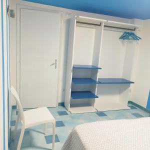 1 dormitorio con cama, silla y armario en Casa Vacanze Miranda, en Torre dei Corsari