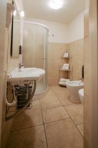 uma casa de banho com um lavatório, um chuveiro e um WC. em Magnolia em Grottaglie