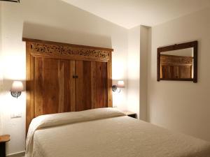a bedroom with a white bed and a mirror at B&B Antico Telaio in Santa Maria Navarrese