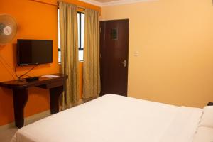 a bedroom with a bed and a desk with a television at Royal Garden Hotel in Lima