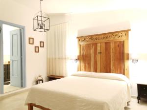 a bedroom with a white bed and a chandelier at B&B Antico Telaio in Santa Maria Navarrese
