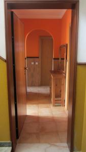 an open door to a room with an orange wall at Correia Holiday Apartment in Fuzeta