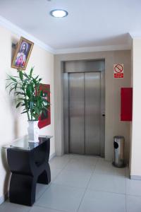 a lobby with a elevator with a potted plant at Royal Garden Hotel in Lima +13 photos