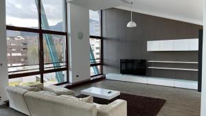Una sala de estar con un sofá y una ventana grande. en TED Penthouse Silver Mountain, en Poiana Brasov