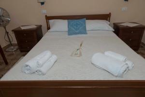 1 cama con 2 toallas y 2 mesitas de noche de madera en Casa A&M en Onifai