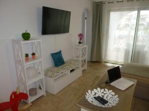 Una sala de estar con un sofá y un televisor en la pared. en Costa Antigua, en Costa de Antigua