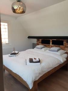 een witte slaapkamer met een groot bed met handdoeken erop bij Bela Vista in Burgh Haamstede