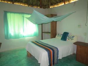 a bedroom with a bed with a mosquito net at Cabañas Calakmul in Conhuas
