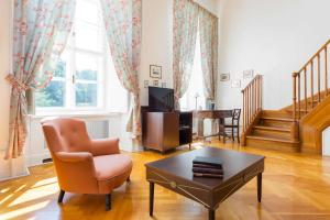 a living room with a chair and a coffee table at Károlyi Kastély Hotel & Restaurant in Fehérvárcsurgó