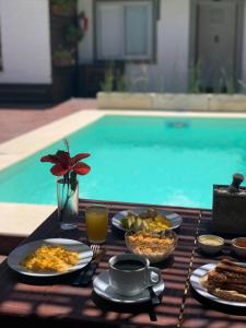 a table topped with plates of food and drinks at TAS D VIAJE Suites - Hostel Boutique in Punta del Este