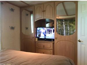 a bedroom with a bed and a tv in a cabinet at ANVIBE 1 in Lathum