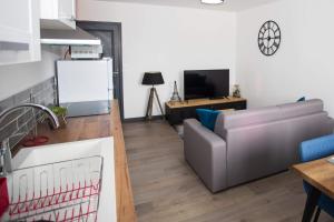 cocina y sala de estar con sofá y mesa en Le ptit coin de la Baie en Fort-Mahon-Plage