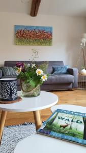 una sala de estar con una mesa con flores. en Zur alten Bäckerei - Finsterbergen, en Friedrichroda