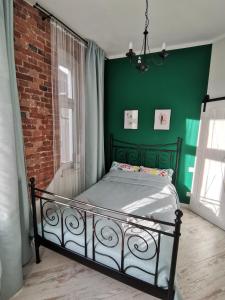 sypialnia z łóżkiem i zieloną ścianą w obiekcie Przytulny apartament w centrum Kupiecka-Drzewna w Zielonej Górze
