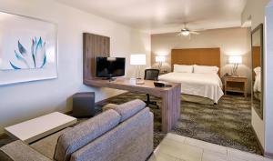 a hotel room with a bed and a couch at Holiday Inn & Suites Chihuahua Expo by IHG in Chihuahua