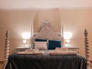 a bedroom with a large bed with blue pillows at Casa da Viela in Arouca