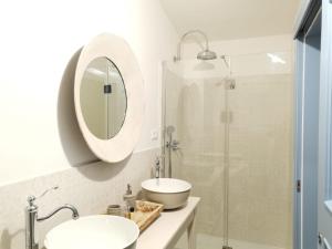 a bathroom with a sink and a shower with a mirror at B&B Antico Telaio in Santa Maria Navarrese