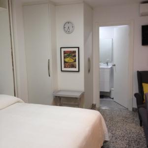 マラガにあるSAN LORENZO STUDIOのベッド1台と壁掛け時計が備わるホテルルームです。