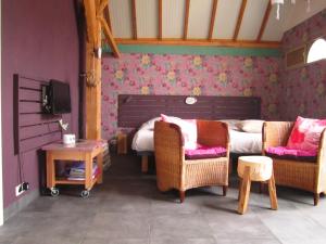 a bedroom with a bed and chairs and a tv at Bed and Breakfast Klein Groenbergen in Leersum