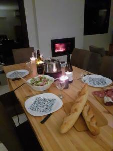 een houten tafel met borden en schalen van voedsel bij Vaste appartement 3 chambres - Vue exceptionnelle in Chorges