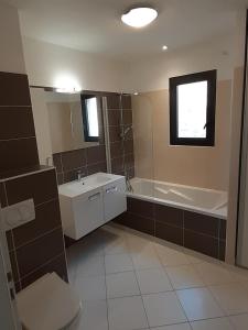 a bathroom with a sink and a tub and a toilet at Vaste appartement 3 chambres - Vue exceptionnelle in Chorges