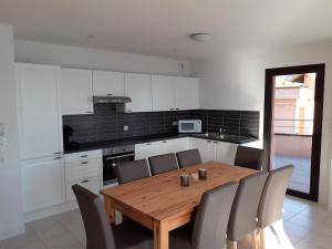 a kitchen with a wooden table and some chairs at Vaste appartement 3 chambres - Vue exceptionnelle in Chorges