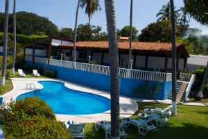 a resort with a swimming pool and palm trees at Coral Clubes Acapulco in Acapulco