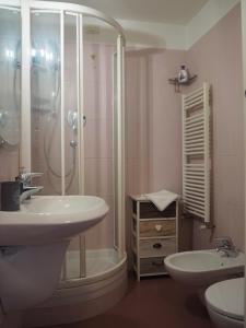 La salle de bains est pourvue d'un lavabo et d'une douche. dans l'établissement Amba Alagi Apartment, à Gênes