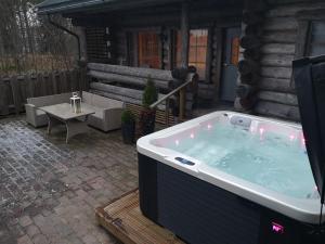 a large hot tub on a patio with a table at Pohjolantuvat in Gerknäs