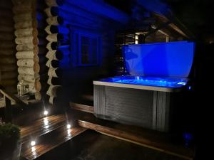 a bathroom with a blue tub with a tv at Pohjolantuvat in Gerknäs