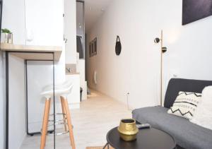 un salon avec un canapé et une table dans l'établissement HYPER CENTRE VALENCIENNES - WIFI - TERRASSE - TRAMWAY - leRelaisdOdile2, à Valenciennes 9 autres photos
