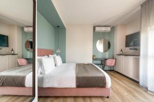 a bedroom with a large bed and a bathroom at Dizengoff Garden Hotel in Tel Aviv