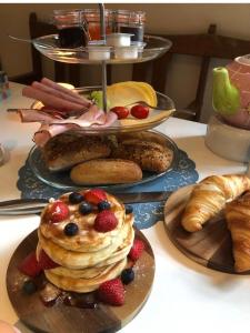 uma mesa coberta com pratos de panquecas e pastelaria em B&B Zeeuws genoegen em Vlissingen