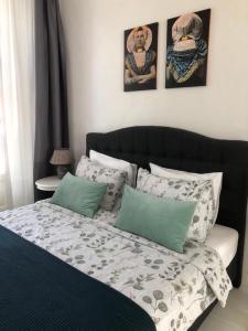 a bedroom with a bed with green and white pillows at Appartement Zeeuws genoegen in Vlissingen