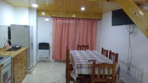 una cucina con tavolo e una cucina con tavolo. di EDIFICIO COSTANERA a Las Toninas Altre 18 foto