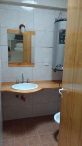 a bathroom with a sink and a mirror and a toilet at EDIFICIO COSTANERA in Las Toninas