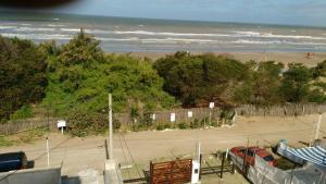 una vista di una spiaggia con una recinzione e un parcheggio di EDIFICIO COSTANERA a Las Toninas