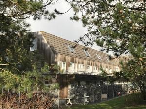 a large wooden building with windows on it at Appartement, Kaap 123 - Ameland in Hollum