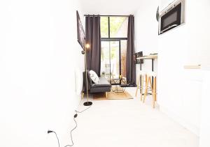 un salon avec une chaise et une fenêtre dans l'établissement HYPER CENTRE VALENCIENNES - WIFI - TERRASSE - TRAMWAY - leRelaisdOdile2, à Valenciennes
