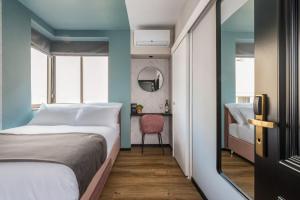 Dizengoff Garden Hotel في تل أبيب: غرفة نوم صغيرة بها سرير وكرسي