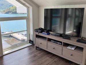 un soggiorno con un grande televisore e una grande finestra di 6 person holiday home in ETNE a Etnesjøen