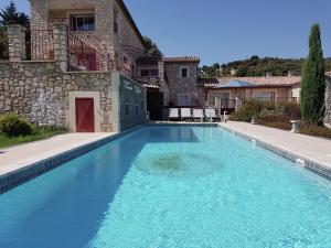 ein großer blauer Pool vor einem Haus in der Unterkunft Holiday home with views and private pool in Saint-Victor-de-Malcap