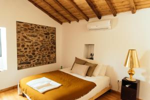 ein Schlafzimmer mit einem Bett in einem Zimmer in der Unterkunft Azeite de Marvão, Olivoturismo casa Venda do Lagar in Marvão