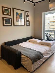 a large bed in a room with pictures on the wall at Unlimited - Frente ao Mar. Apt todo mobiliado. in Santos