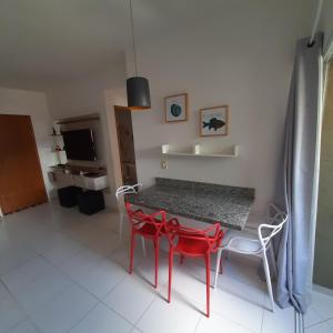 um quarto com uma mesa e cadeiras e uma televisão em APTO PERTINHO DA PRAIA - Lindo e Equipado! Internet 400mb e 3 Tvs - Completo! TV a Cabo em Ubatuba